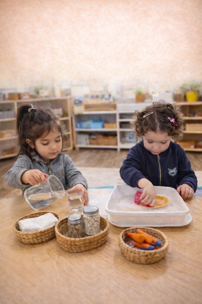 Children doing practical life activities - pouring and washing